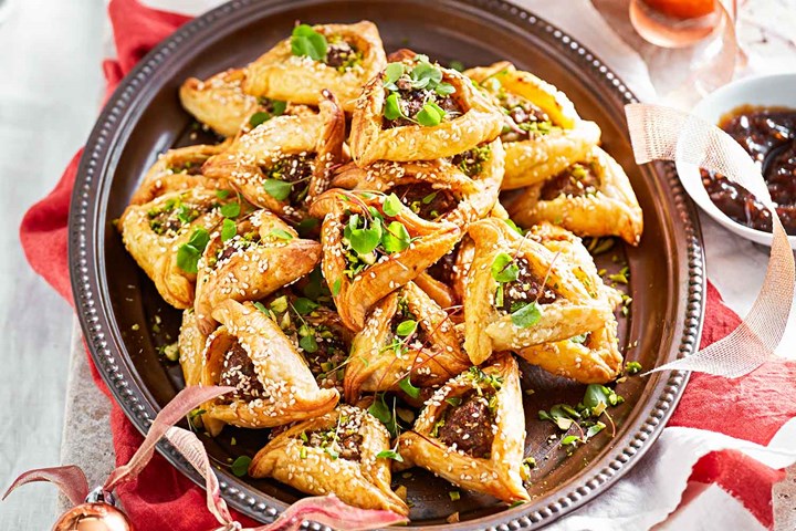 Give your sausage rolls a different twist with dried figs, pistachios and triangle shapes.