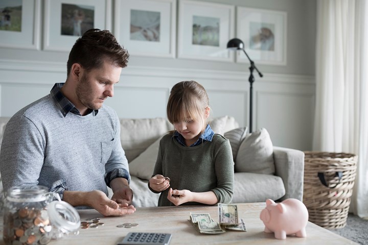 Father teaching daughter how to count money