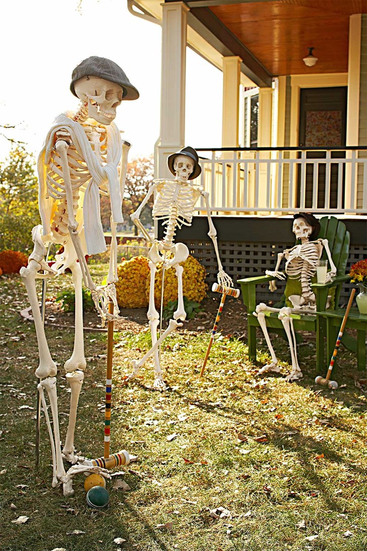 Funny Halloween skeletons posing in front garden