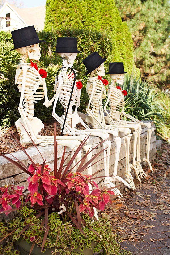 Funny Halloween skeletons posing in garden.