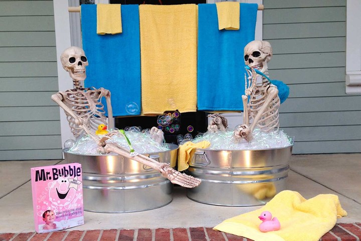 Funny Halloween skeletons posing in a bath