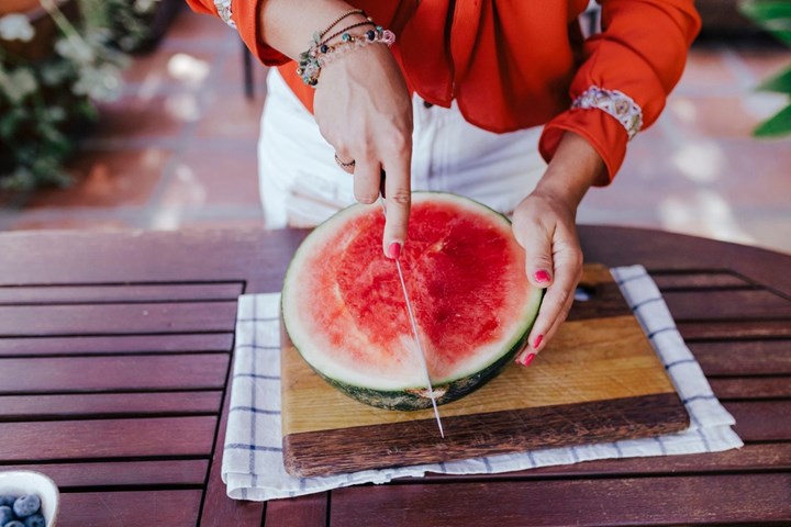 Frau beim Schneiden der Wassermelone
