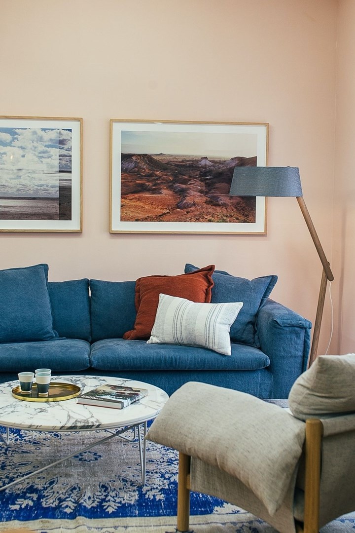 Blue sofa next to a peach coloured wall