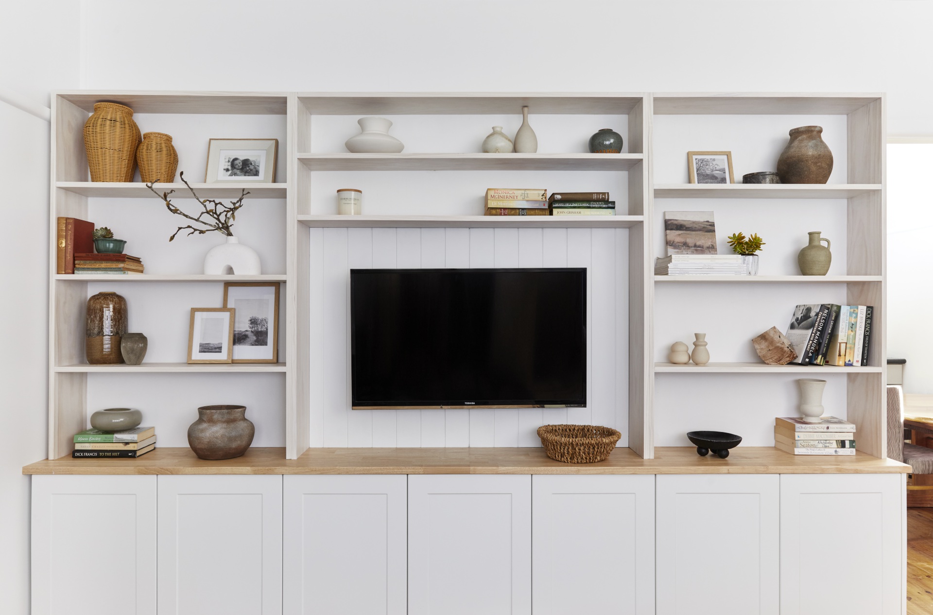 tv unit hutch with vases, knick knacks and books placed around it
