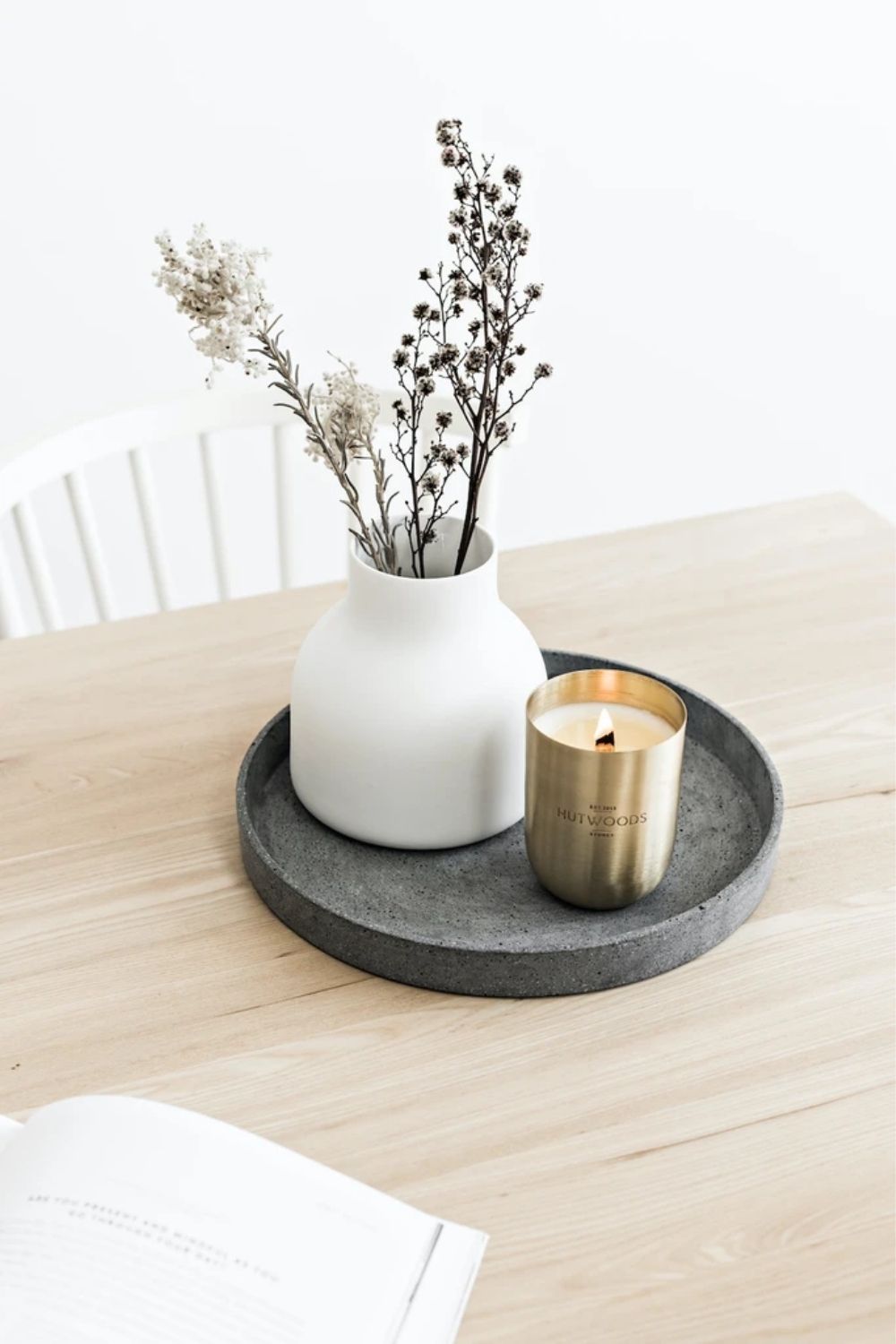 candle and vase of flowers on a marble tray