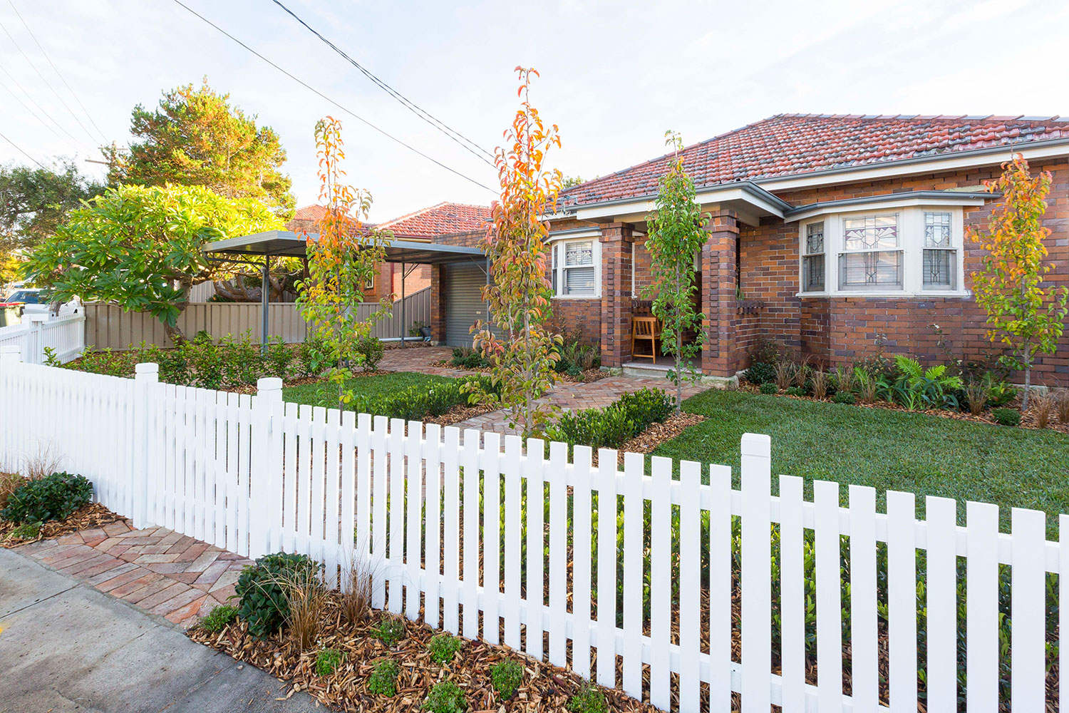 Brick house with white picket fence