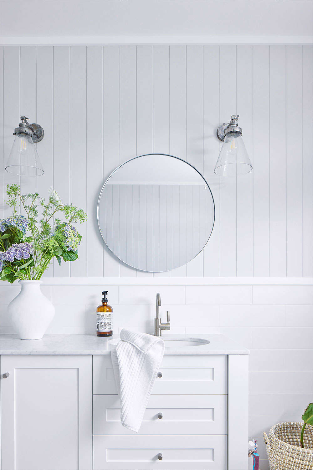 White bathroom with glass wall sconces